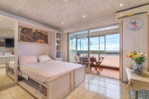 a bedroom with a bed and a view of the ocean at Le Maeva in Saint-Laurent-du-Var