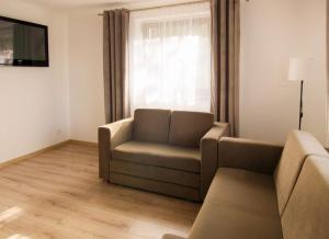 uma sala de estar com um sofá e uma televisão em Pod lasem u Surajów em Huta Lubycka