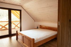 um quarto com uma cama e uma grande janela em Pod lasem u Surajów em Huta Lubycka