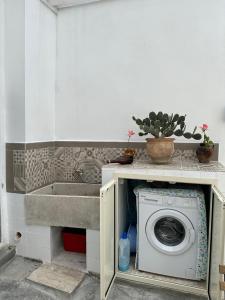 a kitchen with a washing machine and a sink at MiMì House in Nardò