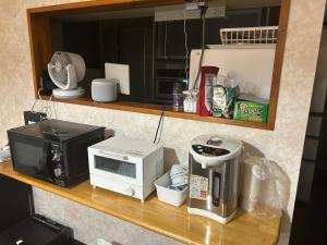 encimera de cocina con microondas y tostadora en 無料駐車場付き個室 大阪と京都へアクセス 良し無人チェックイン, en Yawata