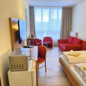 ドナウヴェルトにあるポストホテル トラウブのリビングルーム付きの客室を提供しています。