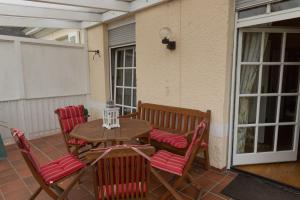 a wooden table and chairs on a patio at La Roseraie in Wittlich