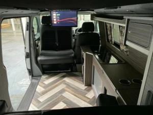 Habitación con TV y vistas interiores a la parte trasera de una caravana. en Stunning VW Camper Van, en Kirton