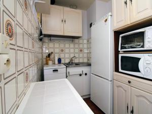 una pequeña cocina con armarios blancos y microondas en Appartement Saint-Cyprien, 2 pièces, 4 personnes - FR-1-309-370, en Saint-Cyprien