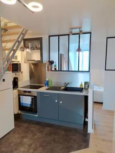 a large kitchen with a sink and a stove at ☆ T2 hypercentre ✢ plage à 400m ✢ tout équipé ☆ in Dinard