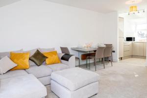 2 Bed Free Private Parking Leisure Contractor في Higham Ferrers: غرفة معيشة بيضاء مع أريكة وطاولة