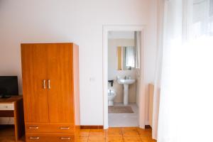 a bathroom with a toilet and a wooden cabinet at B&B Ulisse in Ispica