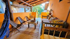 a living room with two chairs and a table at Vila no Rosa Hospedaria in Praia do Rosa