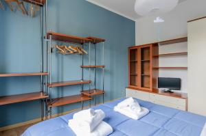 een blauwe slaapkamer met een bed en houten planken bij Bell’occhio Colorful Apartment with parking in Perugia