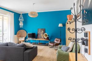 a living room with a couch and a blue wall at Bell’occhio Colorful Apartment with parking in Perugia