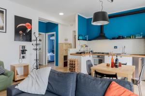 een woonkamer met een bank en een keuken bij Bell’occhio Colorful Apartment with parking in Perugia