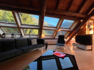 a living room with a couch and some windows at The Loft 3 minutes from Alpe dHuez Grand Domaine via Oz en Oisans in Oz