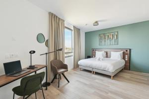 a bedroom with a bed and a desk with a computer at All Suites Appart Hôtel - Paris Ouest - Colombes in Colombes