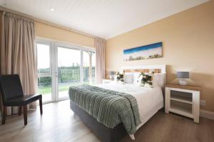 a bedroom with a bed and a large window at The Cabin on the Rock in Skoenmakerskop