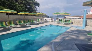 a swimming pool with chairs and umbrellas at Hotel Da Maria in Ischia