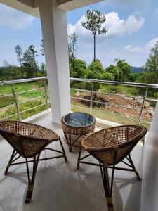 balcón con 3 sillas, mesa y vistas en Coffee valley resort (CVR), en Yercaud