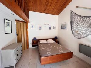 a small bedroom with a bed and a television at Maison avec cour, à 25m de la plage, proche centre et commerces - FR-1-197-573 in Les Sables-dʼOlonne