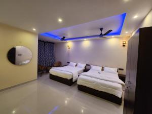 a hotel room with two beds and a mirror at Coffee valley resort (CVR) in Yercaud