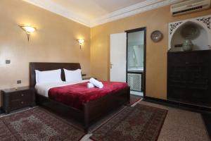 Un dormitorio con una cama grande con una manta roja. en HOTEL CTM, en Marrakech 9 fotos más