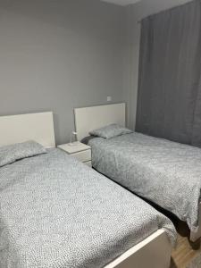 ein Schlafzimmer mit 2 Betten und einer Lampe auf einem Nachttisch in der Unterkunft Exclusive Apartment Nha Kubico in Madeiral