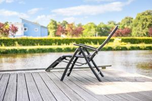 a chair sitting on a dock next to a river at Summio Waterpark De Bloemert in Zuidlaren