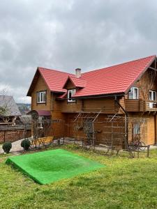 une maison avec un putting-green devant une maison dans l'établissement Марічка Marichka, à Vorokhta