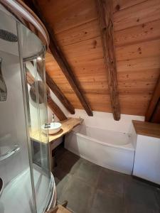 a bathroom with a tub and a wooden ceiling at The Loft 3 minutes from Alpe dHuez Grand Domaine via Oz en Oisans in Oz