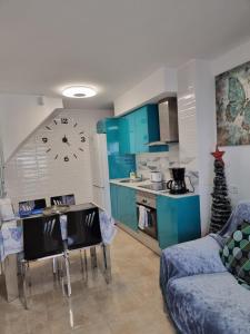 a kitchen with blue cabinets and a clock on the wall at Sonnenland Meloneras & Maspalomas in Maspalomas