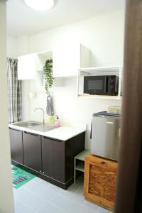 a kitchen with a sink and a microwave at Cozy room in Khlongluang in Khlong Luang