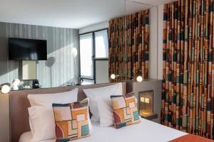 a bedroom with a bed and a wall of books at Le 7 Eiffel Hotel by Malone in Paris