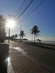 una calle vacía con palmeras y un semáforo en Apartamento, ampla sacada com vista para o mar!, en Itanhaém