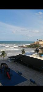 vistas a una playa con palmeras y al océano en Apartamento, ampla sacada com vista para o mar!, en Itanhaém