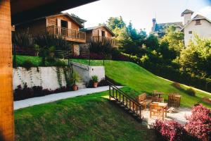 a house on a hill with a table and chairs at Pousada Aberdeen in Campos do Jordão