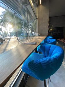 a row of blue chairs sitting at a bar at Admiral Hotel in Milan