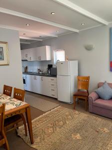 een keuken en een woonkamer met een tafel en een bank bij Peaceful Perch in Walvis Bay