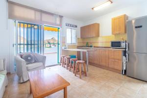 eine Küche mit einem Kühlschrank sowie einem Tisch und Stühlen in der Unterkunft Flatguest Namibia SIN ASCENSOR in Mogán