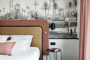 sypialnia z łóżkiem i zdjęciem palm w obiekcie Best Western Hotel du Pont Wilson w mieście Lyon