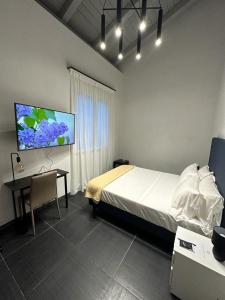 a bedroom with a bed and a desk and a flat screen tv at Dazio Exclusive Rooms in Rome