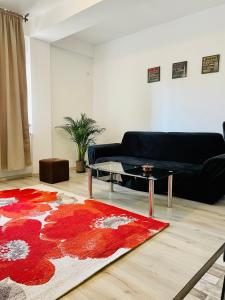 sala de estar con sofá y alfombra roja en Dream Sury Apartment - metrou Leonida, spital Obregia, en Bucarest
