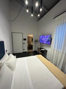 a bedroom with a large white bed and a flat screen tv at Dazio Exclusive Rooms in Rome