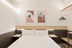 a bedroom with a bed and two pictures on the wall at Bcn Town Apartments Born in Barcelona