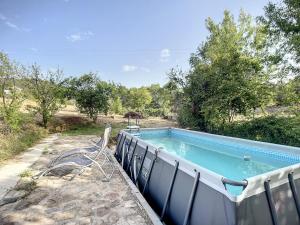 - une piscine avec une chaise à côté dans l'établissement Maison La Tour-sur-Orb, 3 pièces, 4 personnes - FR-1-451-200, à La Tour-sur-Orb