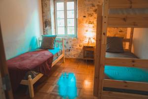 a room with two bunk beds and a window at Le Moulin de L'Isle - Maison chaleureuse in LʼIsle-Bouzon