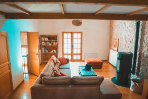 a living room with a couch and a table at Le Moulin de L'Isle - Maison chaleureuse in LʼIsle-Bouzon