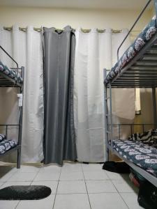 Rovers Boys Hostel Dubai Near Gold Souq Metro في دبي: غرفة بسريرين بطابقين وستارة