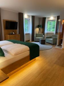 ein Schlafzimmer mit Bett und ein Wohnzimmer in der Unterkunft Hotel Elfbuchen in Kassel