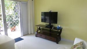 ein Wohnzimmer mit einem Flachbild-TV auf einem Stand in der Unterkunft Rockley Golf Club 309 2 Bed 2 Bath Pool Tennis Bar in Bridgetown