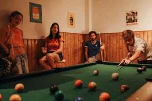 a group of people standing around a pool table at Onefam Sants in Barcelona