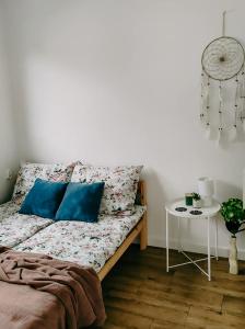 łóżko z niebieskimi poduszkami i stołem w pokoju w obiekcie Domki Zorza w mieście Darłowo
